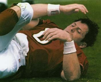 Steve Young, star quarterback for the San Francisco 49ers, is knocked to the ground during a football game. In 2000, after 13 years with the team, Young announced his retirement due to the series of head injuries he sustained on the field. Associated Press/AP