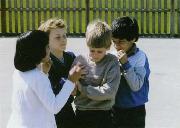 A group of children bullies another student at school. Being physically surrounded and teased by a group can be especially frightening for the bullied child. Jennie Woodcock, Reflections PhotalibrarylCorbis