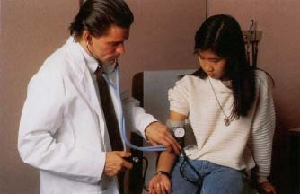 A doctor uses a sphygmomanometer to measure blood pressure. © 1995 Custom Medical Stock Photo.
