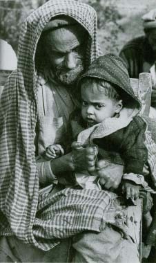 Balakot Leprosy Hospital in Pakistan. A man who has lost his fingers from leprosy is shown with his healthy grandson. © 1973 Bernard Pierre Wolff/Photo Researchers, Inc.